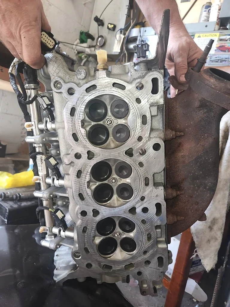 Cylinder head valve work held for inspection in the MotorDoc shop